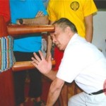 Receiving corrections on the wooden dummy (Mook Yan Chong)